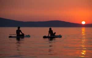 Image showing the silhouettes of a couple enjoying a sunset while paddleboarding on a lake in Texas