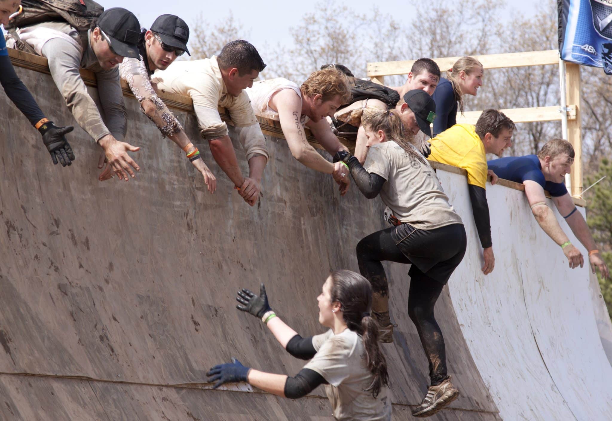 Image of a participants attempting to overcome a Tough Mudder obstacle