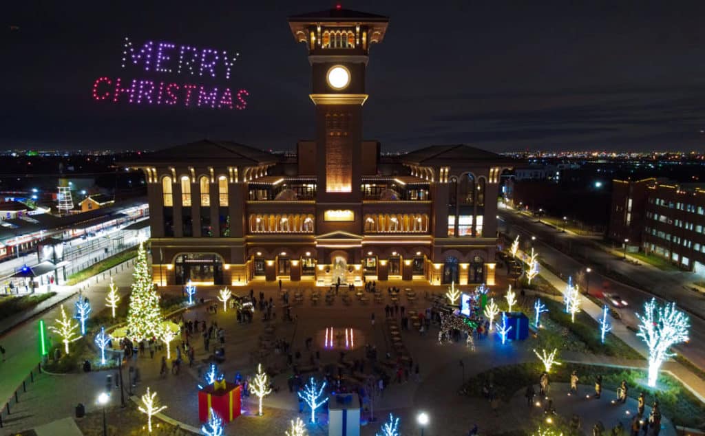 A fleet of drones spell out Merry Christmas above a festive plaza