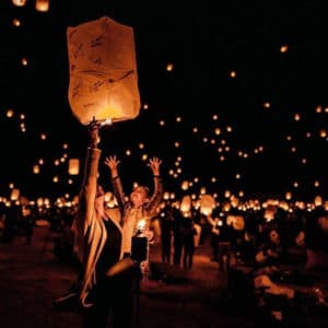 Photo of a mother and child releasing a decorated sky lantern into the sky