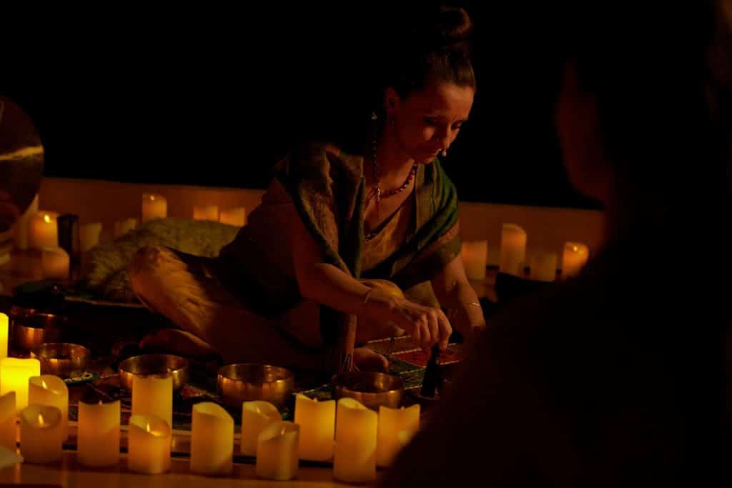 A Mindful Glow instructor sitting surrounded by candles.