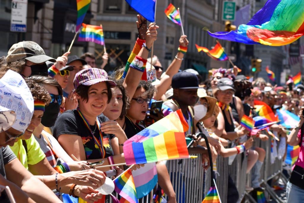 Image of people waving LGBTQ+ flags at a Pride Month celebration in Texas, United States